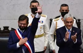 El presidente de Chile Gabriel Boric (i) recibió los atributos presidenciales de la mano del entonces mandatario saliente, Sebastián Piñera. El ex jefe de Estado conservador murió ayer en un accidente aéreo.