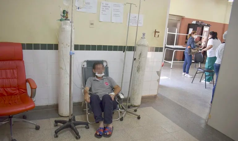Paciente en un sillón plegable y en el pasillo recibe oxígeno en el Hospital de Clínicas. La situación es crítica en varios centros asistenciales debido a la falta de camas y de personal de blanco.