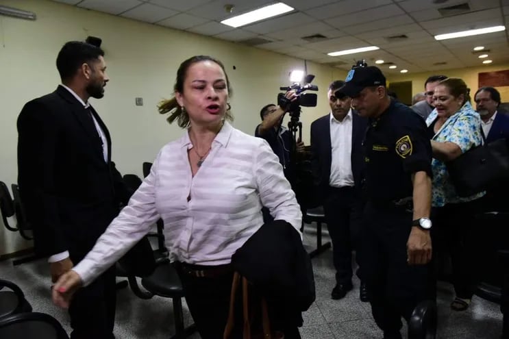 María Selva Verón, esposa de Javier Diaz Verón, se retira gritando a los escrachadores. Detrás del Policía, sale su esposo, también en medio de escraches.
