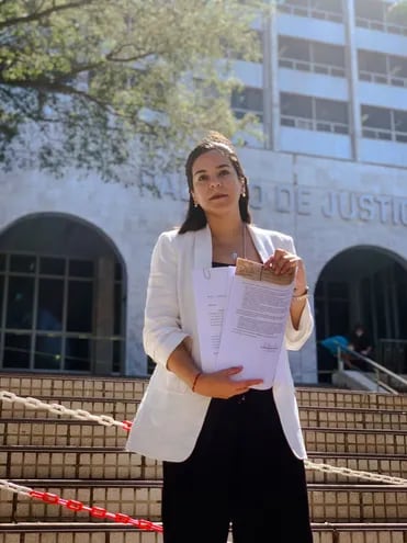 Johanna Ortega, candidata a la intendencia de Asunción, frente al Palacio de Justicia exhibiendo los documentos del amparo.