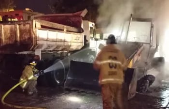 Bomberos tratando de salvar el camión volquete que comenzó a incendiarse