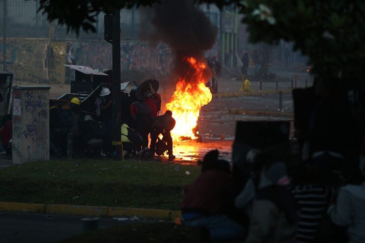 Manifestantes arman barricadas para protegerse durante los enfrentamientos con miembros de la policía a los alrededores de la Casa de la Cultura, en Quito (Ecuador).