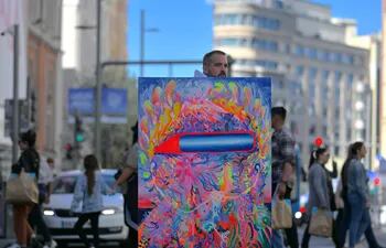 Sebastián Boesmi, en la Gran Vía de Madrid, con uno de los cuadros que formarán parte de la muestra "Ida y Vuelta".