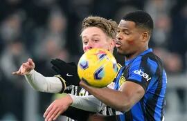 Hans Nicolussi Caviglia (i), de Juventus, y Denzel Dumfries, de Inter, pugna por la posesión del balón, durante el partido que disputaron ayer en Turín y que finalizó empatado 1-1.