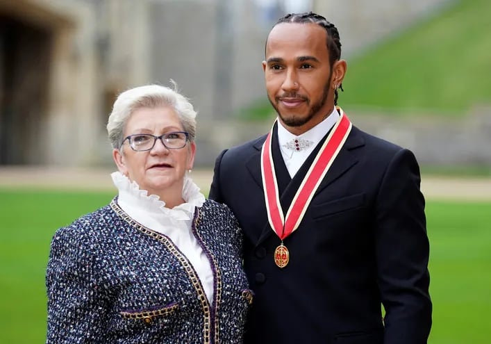 Hamilton  posa con su madre, Carmen Lockhart, tras recibir el título de caballero. AFP