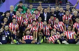 Los jugadores, cuerpo técnico y dirigentes de Paraguay posan con el trofeo de campeón del Preolímpico Sub 23 en el estadio Nacional Brígido Iriarte, en Caracas, Venezuela.