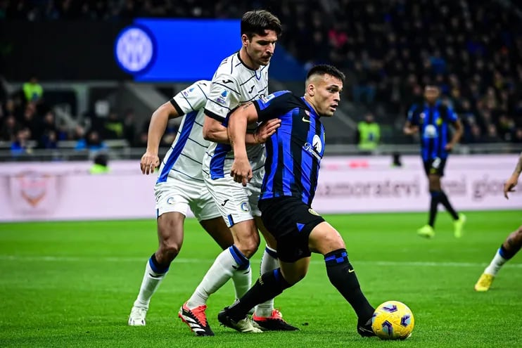 Atalanta's Albanian defender #19 Berat Djimsiti (C) fights for the ball with Inter Milan's Argentine forward #10 Lautaro Martinez (R) during the Italian Serie A football match between Inter Milan and Atalanta in Milan, on February 28, 2024. (Photo by Piero CRUCIATTI / AFP)