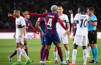 El uruguayo Ronald Araújo (4), jugador del Barcelona, protesta al árbitro por la tarjeta roja que recibió en el partido frente al París Saint-Germain por la vuelta de los cuartos de final de la Champions League en el estadio Olímpico Lluis Companys, en Barcelona, España.