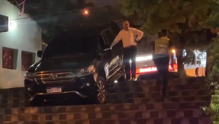 El exsenador Juan Darío Monges parado a lado de su camioneta que cayó en la escalinata de la avenida Carlos Antonio López.