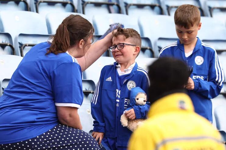 Una madre aficionada del Leicester trata de consolar a su hijo tras consumarse el descenso del equipo, que en el 2016 había logrado el título de la Liga Premier.