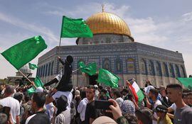 Palestinos ondean banderas dentro del complejo de la mezquita de Al-Aqsa, en Jerusalén.