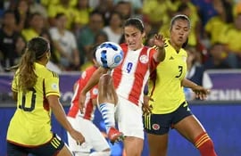 La paraguaya Lice Chamorro (c) intenta controlar el balón ante las colombinas Daniela Arias (d) y Leiciy Santos, durante el partido disputado anoche en Cali.