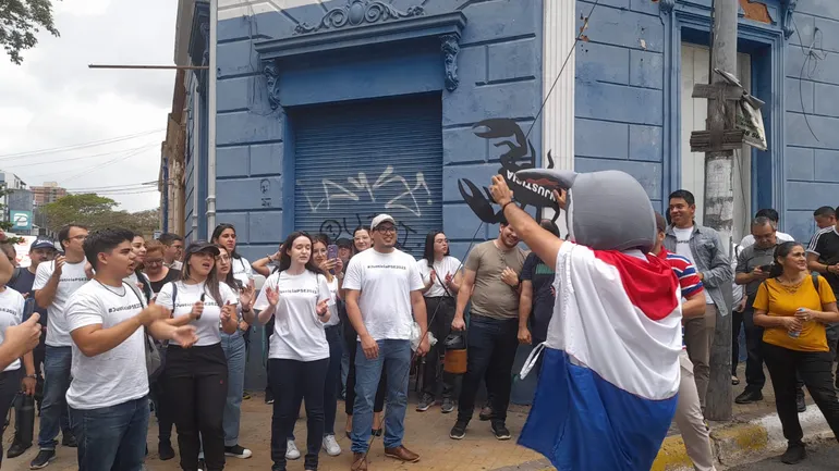 Un grupo de despedidos de la Itaipú Binacional en inmediaciones del Ministerio del Trabajo, aguardando el inicio de la reunión tripartita.