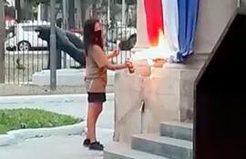 Momento en que  Paloma Chaparro Panimboza quema la bandera paraguaya en el Panteón Nacional de los Héroes, el sábado.