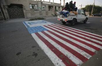 El 3 de enero de 2020 se pinta una simulacro de bandera de EE. UU. En el suelo para que los automóviles circulen en la capital iraquí de Bagdad, luego de la noticia del asesinato del comandante de la Guardia Revolucionaria iraní Qasem Soleimani en un ataque estadounidense contra su convoy en el aeropuerto internacional de Bagdad.