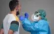 Un trabajador de la salud usa un hisopo para recolectar una muestra de un hombre en un centro de pruebas temporal para el nuevo coronavirus en la ciudad vasca española de Azpeitia.