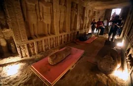 Varias personas inspeccionan los sarcógagos descubiertos en la necrópolis de Saqqara, Giza, Egipto, el 3 de octubre de 2020. Una misión arqueológica egipcia descubrió un total de 59 ataúdes intactos y sellados en tres entierros, a una docena de metros de profundidad en la necrópolis de Saqqara. Se espera que los ataúdes de 2500 años, que se cree pertenecen a los sacerdotes de la 26ª dinastía, sean transferidos al Gran Museo Egipcio.