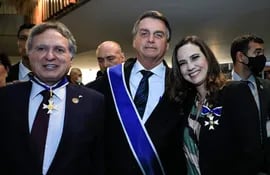 Jair Bolsonaro condecora directivos y consejeros de Itaipú. En la foto, con Anatalicio Risden, director financiero ejecutivo de Itaipú y Mariana Favoreto, directora jurídica de la binacional.