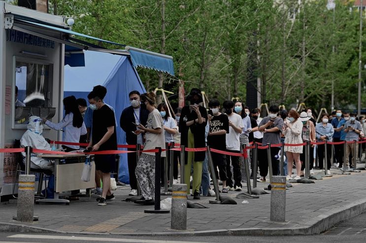 Pobladores de la capital china, Pekín, forman fila para realizarse un test de covid. (AFP)