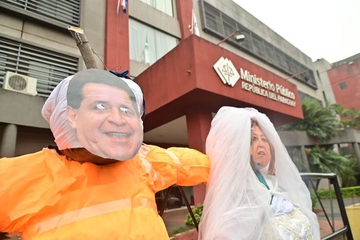 Muñecos de Horacio Cartes, vestido con el mameluco anaranjado que visten los presos en Estados Unidos, y de Sandra Quiñónez participan de un casamiento koygua  frente a la sede de la Fiscalía General del Estado (FGE).