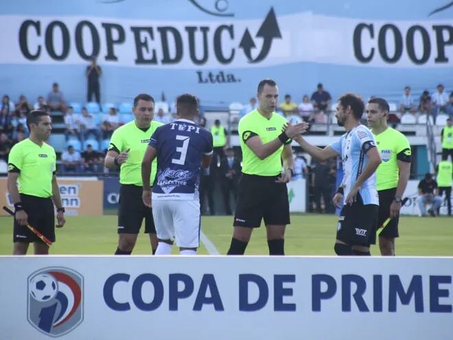 Los jugadores de Sportivo Ameliano y Guaireña saludan a los árbitros en la previa del partido por el fútbol paraguayo 2022 en el Parque del Guairá de la ciudad de Villarrica.