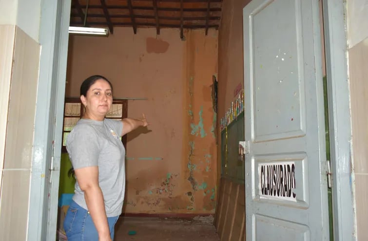 La directora de la Escuela Villarrica del Espíritu Santo, Noelia Guillén Lobos, señalando una de las aulas que se encuentran clausuradas por peligro de derrumbe.