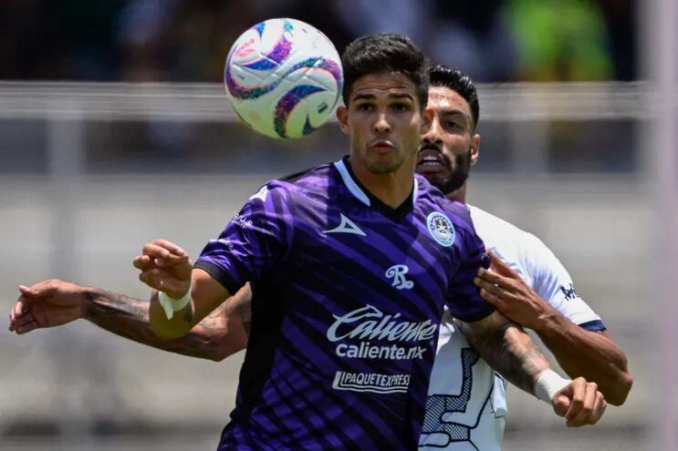 Luis Amarilla, del Mazatlán, intenta controlar el balón ante la marca de Nathan Silva, de los Pumas.