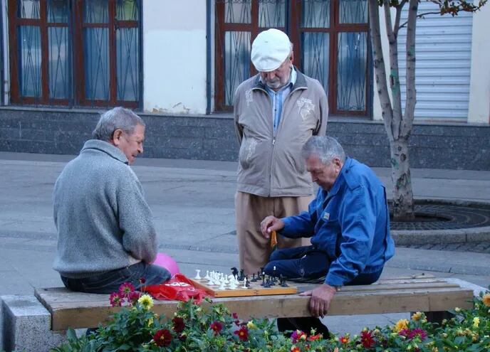 Hombres de la tercera edad juegan al ajedrez en una plaza. La investigación coordinada por la Universidad Autónoma de Barcelona (UAB), en España, identificó una diana terapéutica para neutralizar las formas tóxicas de la proteína asociada al párkinson.