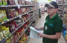 Un estudiante de la UNE cuando anotaba los precios en un supermercado para la elaboración del informe.