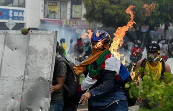 Un manifestante es alcanzado por un cóctel molotov durante los enfrentamientos con agentes de la policía antidisturbios en Cali, Colombia, el 3 de mayo de 2021.