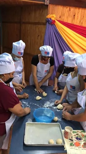 Un grupo de mujeres participa de un curso de panadería, con los elementos de protección dados por la Sinafocal.