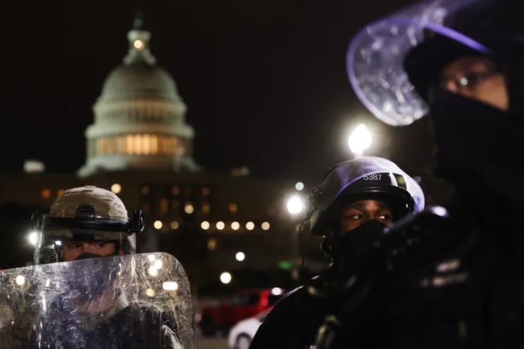 Miembros de la Guardia Nacional y de la Policía de Washington D.C. mantiene a un pequeño grupo de manifestantes alejado del Capitolio, luego de que los partidarios de Donald Trump atacaran el edificio del Capitolio.