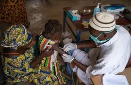 La referencia de la imagen es: Una niña recibe la vacuna contra el sarampión en Mali.