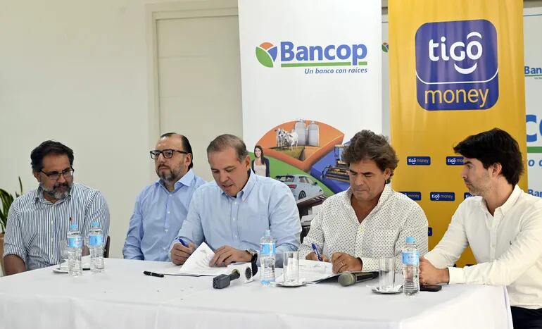 Dimas Ayala, Gerente General de Bancop, y Hernán Chichizola, Director de Tigo Money, firmaron esta importante alianza.
