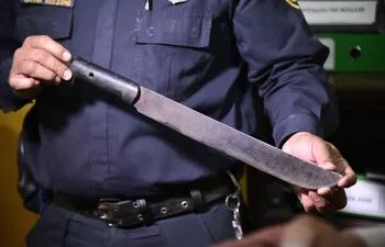 El agente de Policía exhibe el machete que portaba Gustavo Ramón Prieto, de 27 años.
