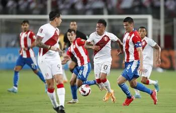 Christian Cueva (c) de Perú disputa el balón con Fabián Balbuena (d) de Paraguay hoy durante un partido de las eliminatorias sudamericanas para el Mundial de Qatar 2022 entre Perú y Paraguay, en el estadio Nacional en Lima (Perú).