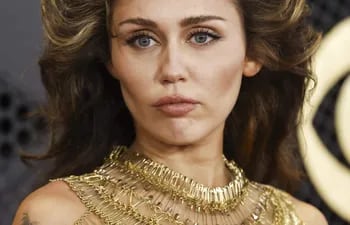 La cantante Miley Cyrus llegando a la alfombra roja de los Premios Grammy con su espectacular tenida dorada.