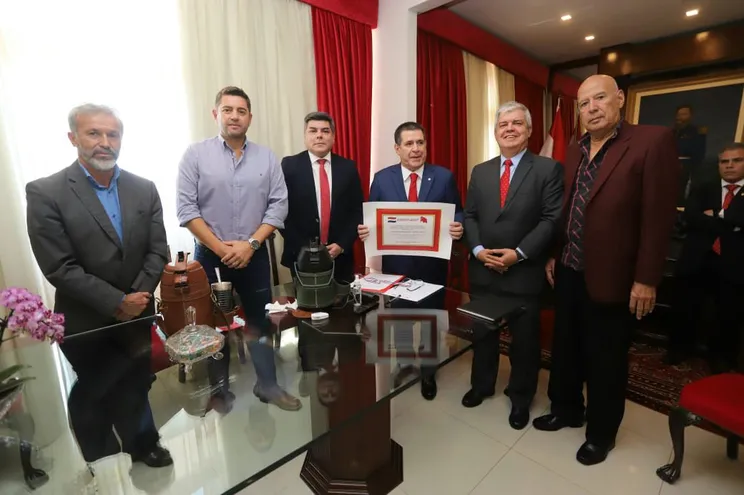 El presidente de la ANR, Horacio Cartes sostiene su "reconocimiento". A su lado están el procesado José Antonio Caballero Bobadilla y el senador Enrique Riera.