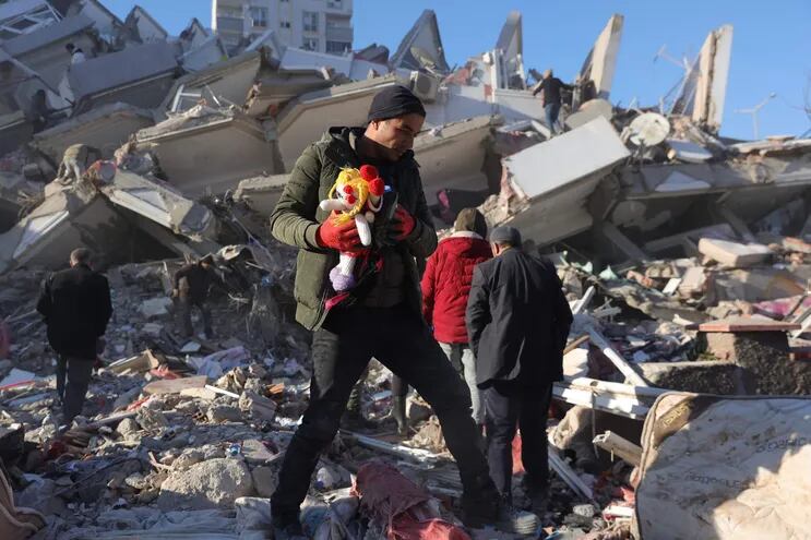 Personas sacan pertenencias de entre los escombros de un edificio derrumbado en la ciudad de Kahramanmaras, sureste de Turquía.