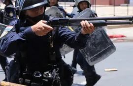 Un agente de la Policía Nacional dispara durante las manifestaciones en contra de la aprobación en la Cámara de Senadores de la ley que crea la Superintendencia de Jubilaciones.