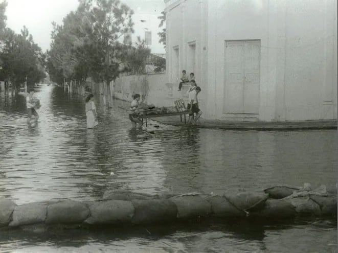 Se observa a familias tratando de rescatar sus cosas y huir de la inundación en mayo de 1983 en pleno centro de la ciudad de Pilar.
