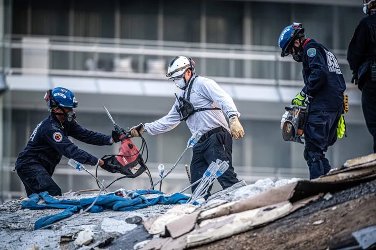 Miembros del equipo de búsqueda y rescate urbano del sur de Florida trabajan hoy, en los escombros del edificio de condominios de 12 pisos parcialmente derrumbado en Surfside, Florida (EE.UU.).
