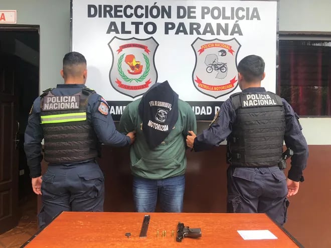 Fabio Alcaraz Duarte y el arma de fuego que tenía consigo en sede de la Policía Motorizada.