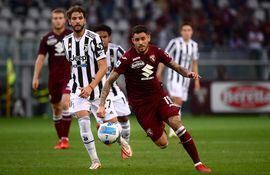 Torino's Italian forward Antonio Sanabria (R) runs for the ball in front of Juventus' Italian midfielder Manuel Locatelli during the Italian Serie A football match between Torino and Juventus at the "Grande Torino Stadium" in Turin on October 2, 2021. (Photo by MARCO BERTORELLO / AFP)