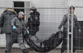Trabajadores sanitarios llevan uno de los cuerpos de las víctimas del tiroteo en la sala de conciertos del Crocus City Hall en Krasnogorsk, a las afueras de Moscú, este sábado.