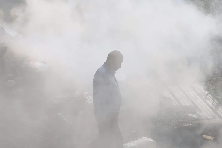 Un hombre palestino entre los escombros y el humo en el sitio de un ataque de colonos israelíes en la localidad de Al-Mughayyir, en Cisjordania, el pasado 13 de abril.