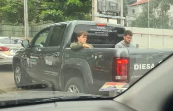 Javier Garrido (d), jugador de Pádel, en la parte trasera de una camioneta oficial del evento en la calles de Asunción.
