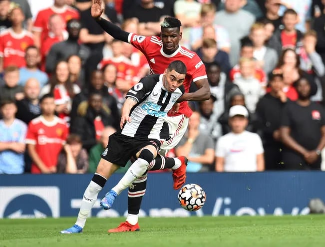 Miguel Almirón se anticipa con el balón ante la marca del francés Paul Pogba, en el partido del Newcastle contra Manchester  United.