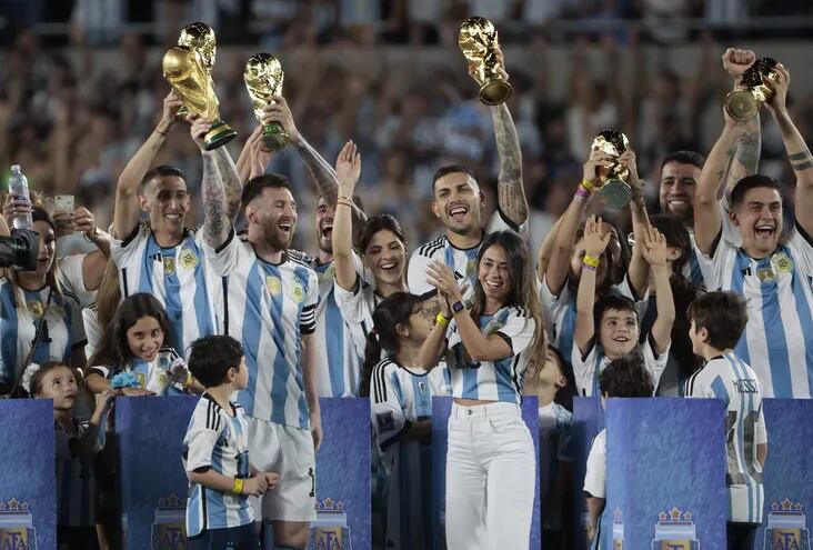 Lionel Messi (i) de Argentina levanta el trofeo de la Copa Mundo en un homenaje acompañado de su esposa Antonela Roccuzzo (d), al final de un partido amistoso entre las selecciones de Argentina y Panamá en el estadio Monumental en Buenos Aires (Argentina). EFE/ Juan Ignacio Roncoroni