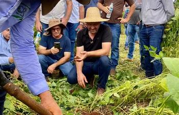 Laercio Dalla Vecchia (sombrero) observa como Cleandro Rossetti remueve la arena en un campo de soja. El campeón brasilero en productividad de soja compartió su experiencia con productores.